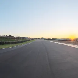 Sunset over racetrack providing dynamic lighting for 3D rendering with clear skies and detailed road surface.