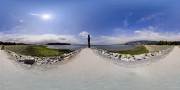 360-degree HDR panorama for lighting with vibrant blue sky, sun flare, and clear coastal path.