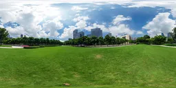 Panoramic HDR image of a sunny urban park with skyscrapers in the background for realistic scene lighting.